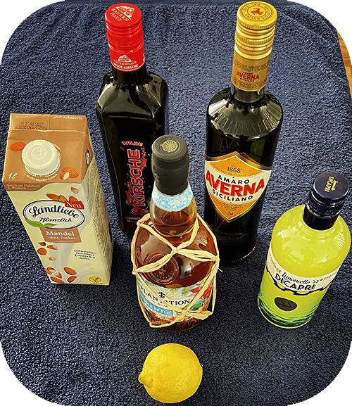 Die Zutaten: Rum, Kirschlikör, Limoncello, Bitterlikör, Mandelmilch und eine Zitrone